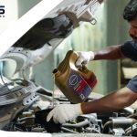 Technician performing an engine oil change using Nissan synthetic motor oil at PitPros car service center in Dubai Investment Park 2.